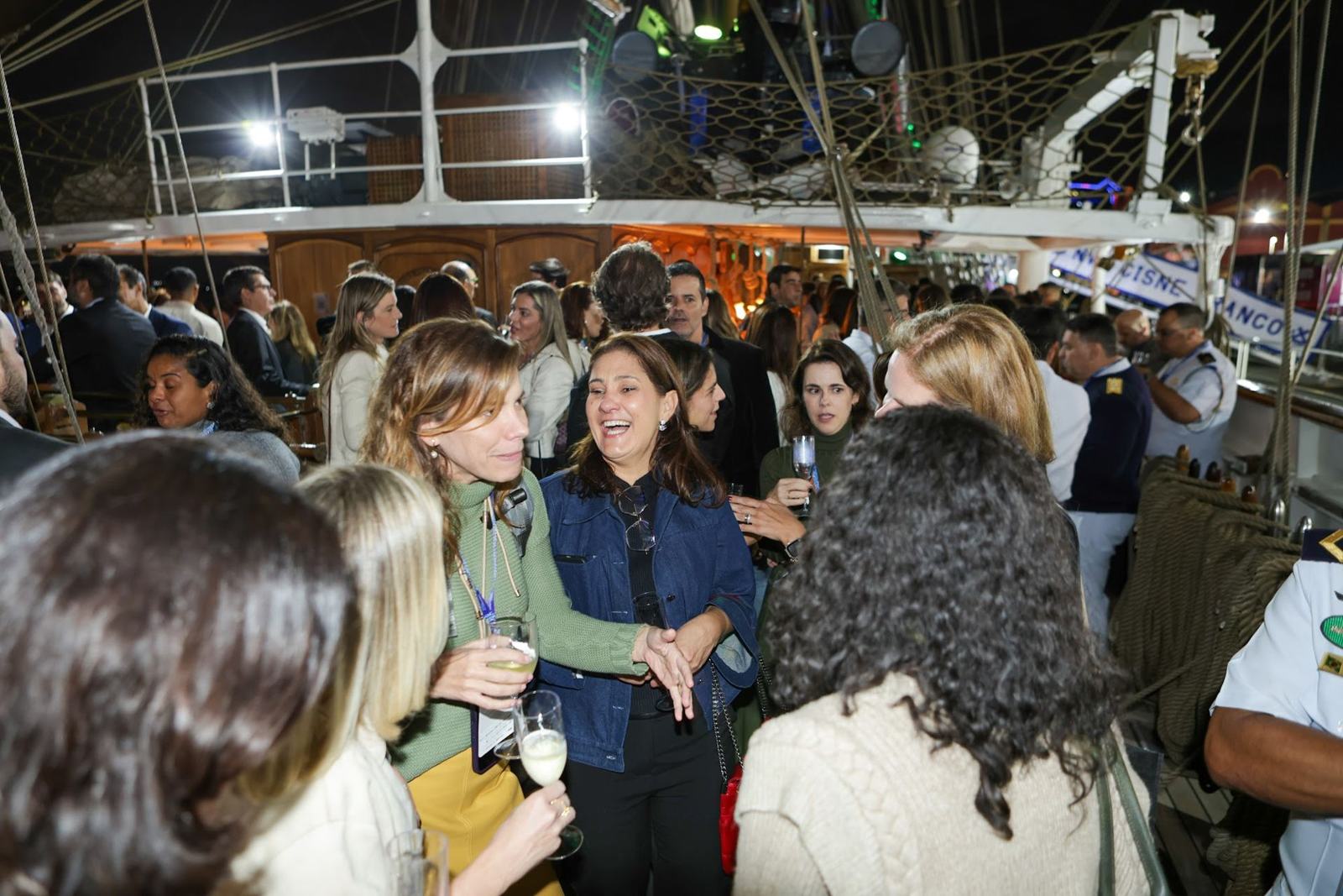 Guests at a happy hour on board Cisne Branco at night