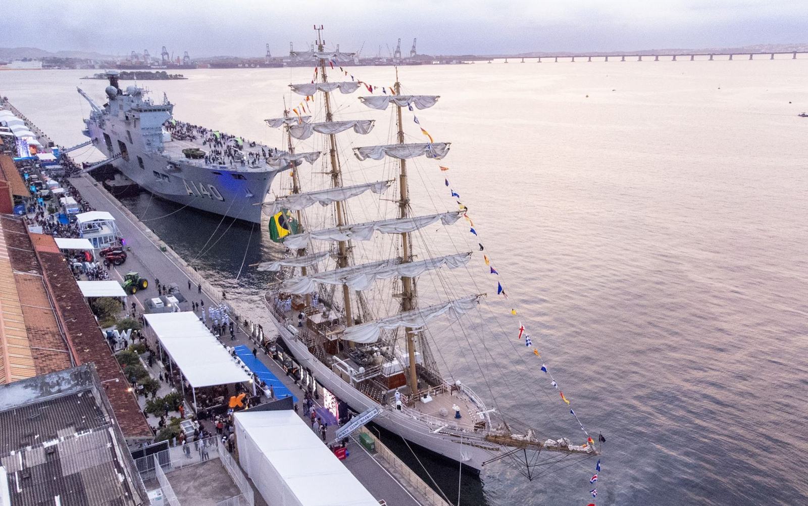 Aerial view of Pier Mauá during RIW 2025, with NAM Atlântico and the tall ship Cisne Branco docked beside the warehouses