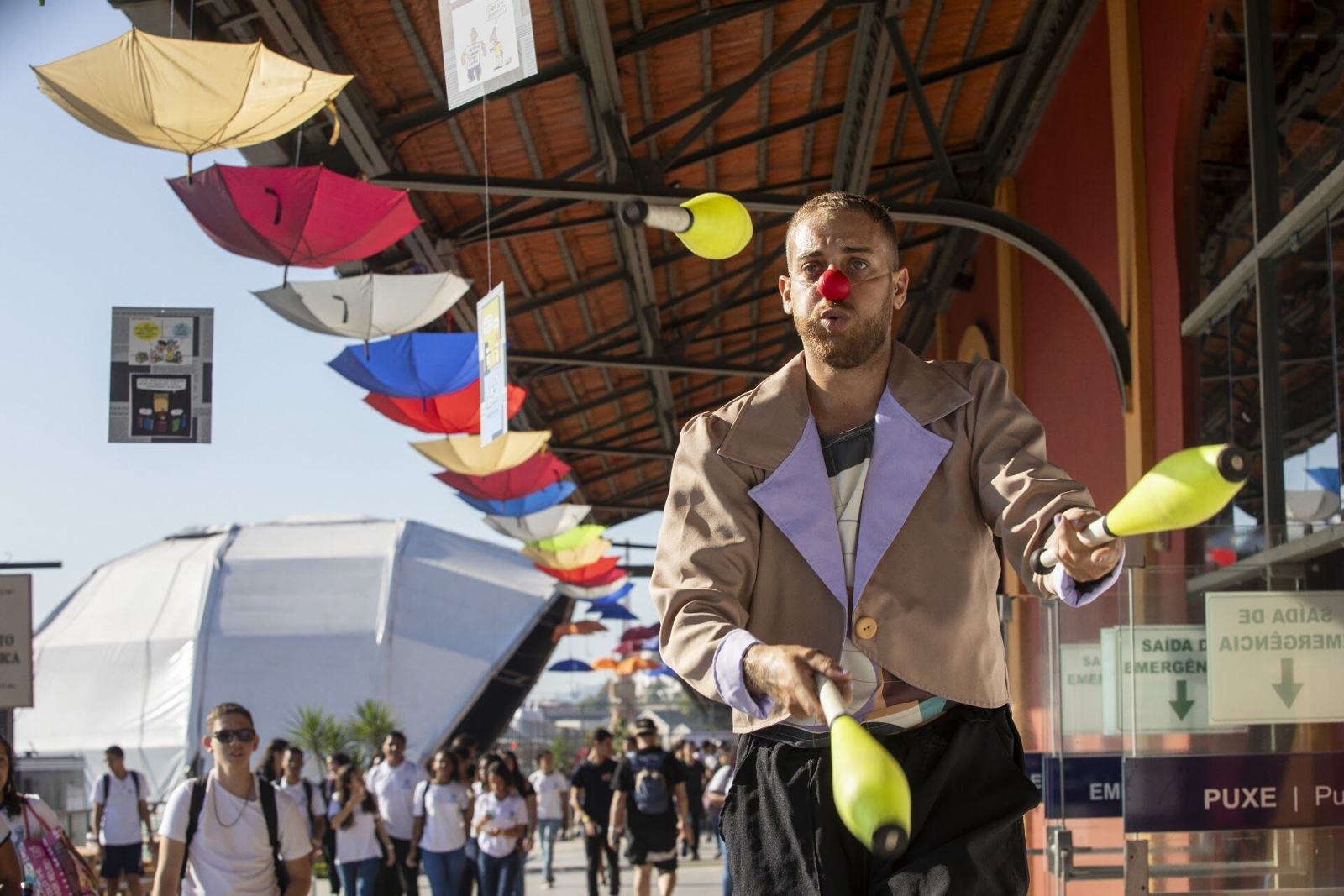 Performer juggling under colorful umbrellas