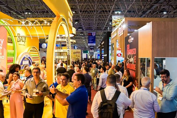 Busy aisle of colorful booths at Super Rio Expofood